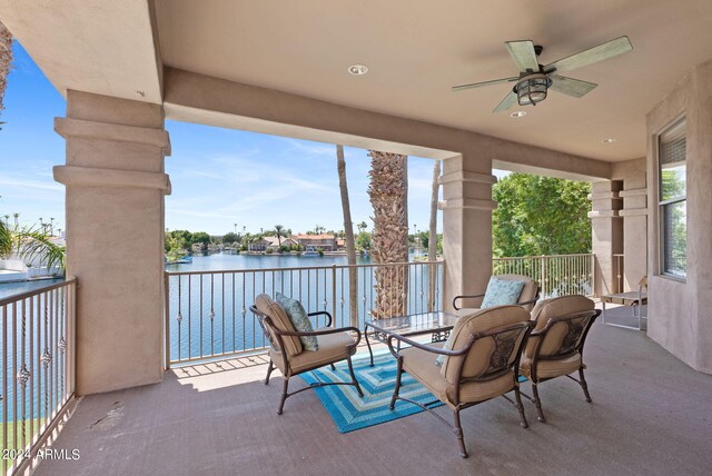 balcony featuring a water view and ceiling fan