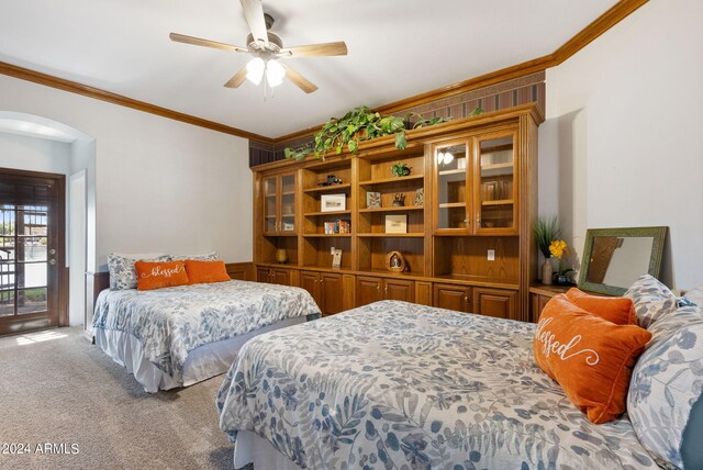 bedroom with wood walls, carpet, ceiling fan, and ornamental molding