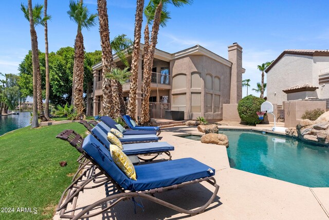 view of patio featuring area for grilling, a wet bar, a water view, and ceiling fan