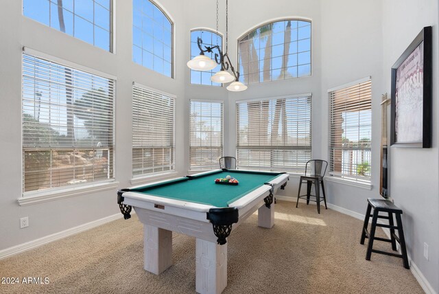 recreation room featuring light colored carpet, billiards, and a towering ceiling