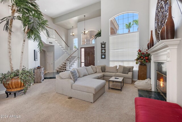 carpeted living room with a fireplace, plenty of natural light, and a high ceiling