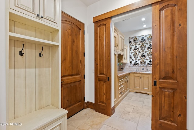 bathroom featuring tile flooring, backsplash, and vanity