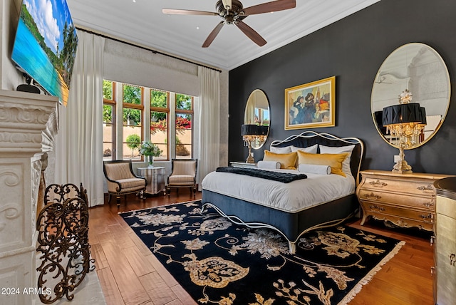 bedroom with ceiling fan, ornamental molding, and wood-type flooring