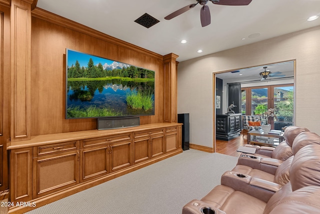 living room featuring light hardwood / wood-style floors, wood walls, ceiling fan, and a water view