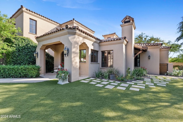 mediterranean / spanish-style home with a front yard and central AC