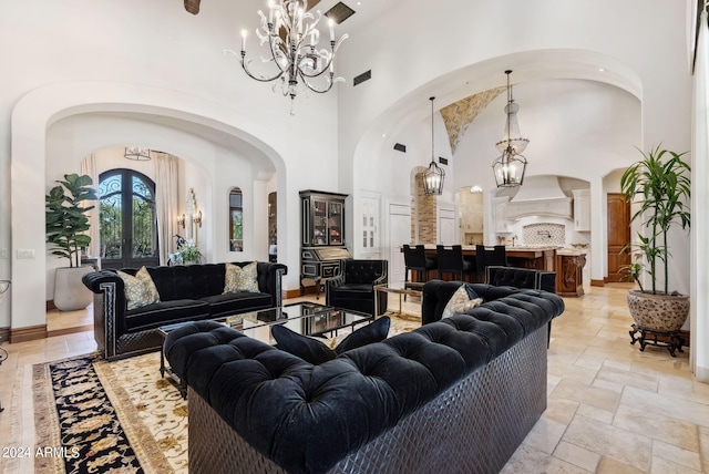 tiled living room with a towering ceiling and a chandelier