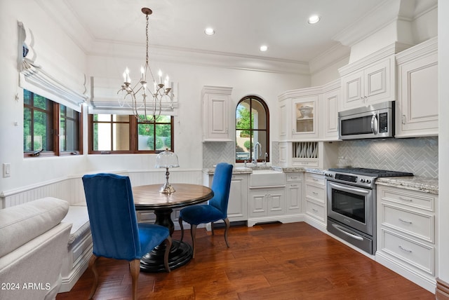 kitchen with appliances with stainless steel finishes, sink, tasteful backsplash, and dark hardwood / wood-style flooring