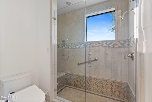 bathroom with a shower with door and toilet