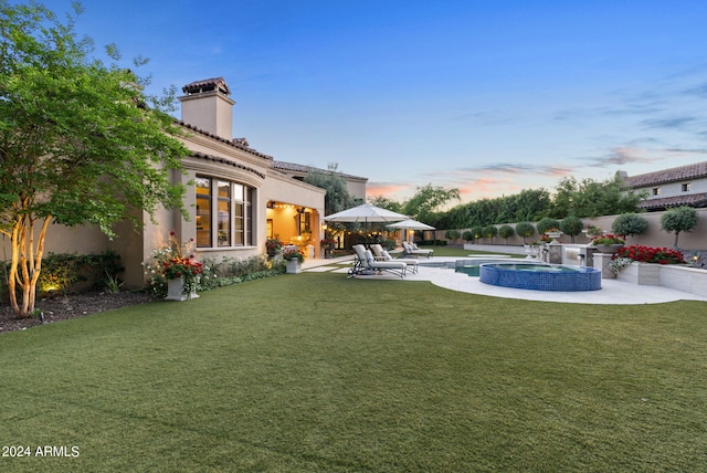 yard at dusk with a patio area