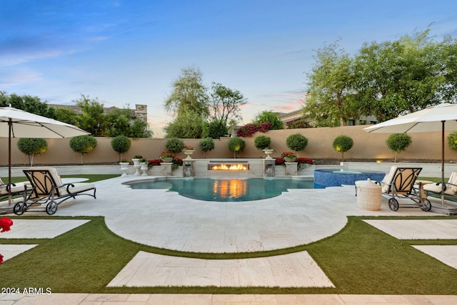 pool at dusk featuring a patio area