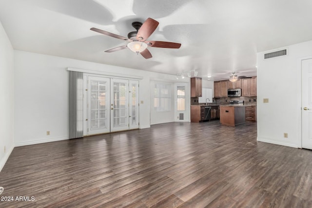 unfurnished living room with ceiling fan, sink, and dark hardwood / wood-style floors