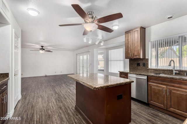 kitchen featuring sink, dark hardwood / wood-style flooring, stainless steel dishwasher, backsplash, and a kitchen island