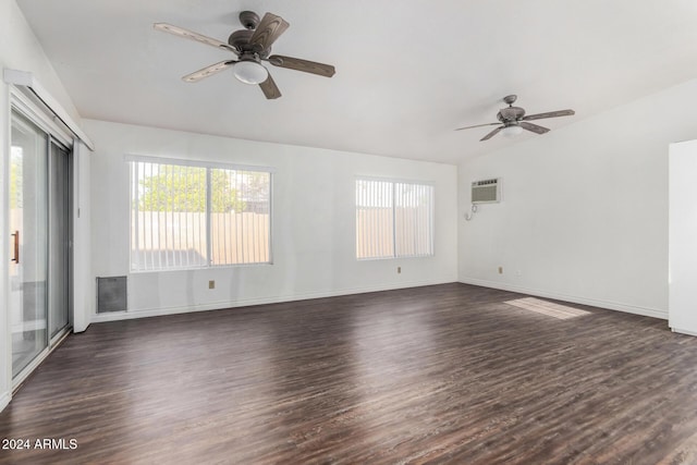 empty room featuring a wall mounted air conditioner, dark hardwood / wood-style floors, and ceiling fan