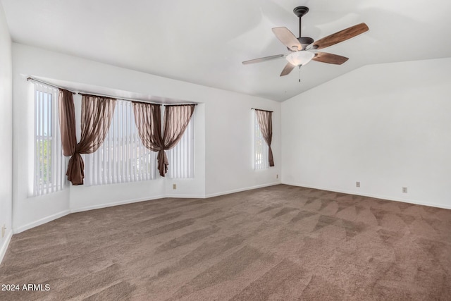 carpeted spare room with ceiling fan and vaulted ceiling