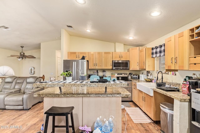 7259 E Glencove St, Mesa, AZ 85207 - kitchen with stainless steel appliances, light brown cabinets, vaulted ceiling, a center island, and light wood-type flooring