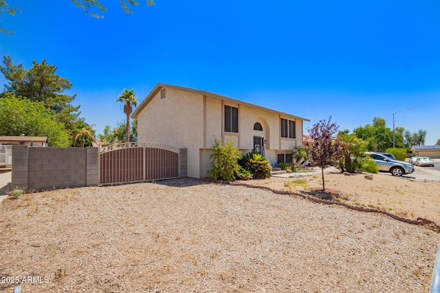 7259 E Glencove St, Mesa, AZ 85207 - bi-level home with stucco siding and a gate