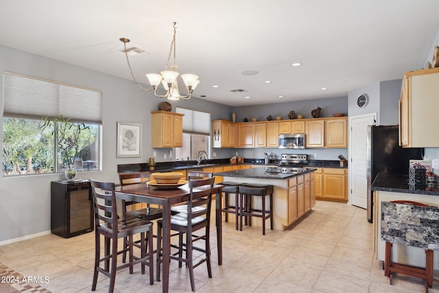 kitchen featuring a kitchen breakfast bar, a kitchen island, an inviting chandelier, pendant lighting, and stainless steel appliances