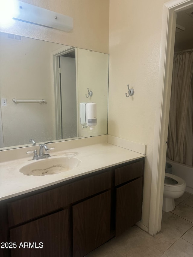 full bathroom with toilet, vanity, and tile patterned flooring