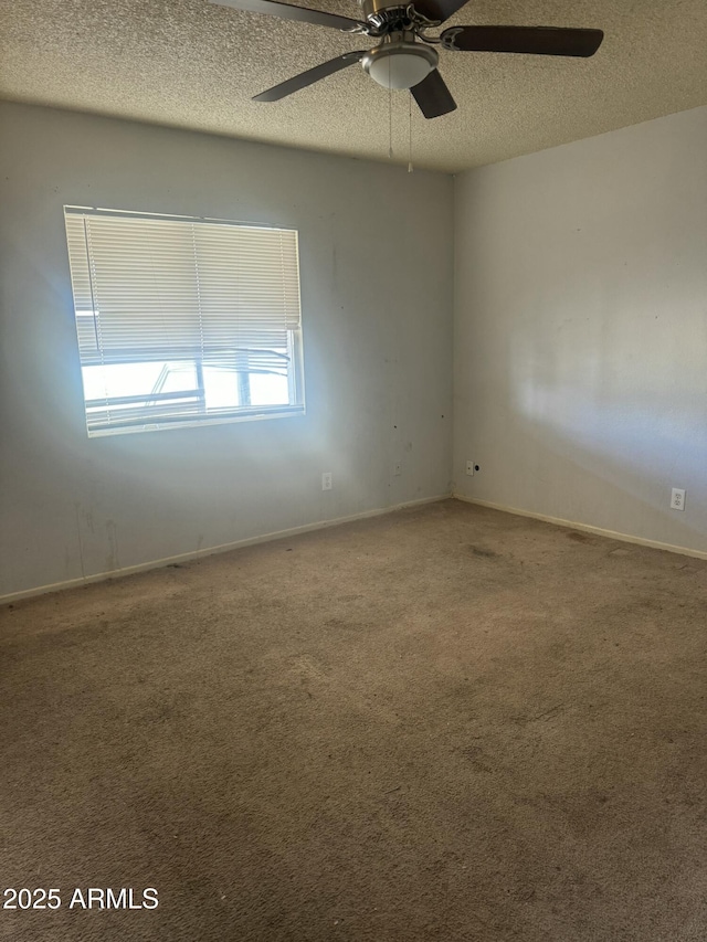 spare room featuring baseboards, carpet, ceiling fan, and a textured ceiling