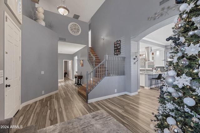 foyer with light hardwood / wood-style floors and high vaulted ceiling