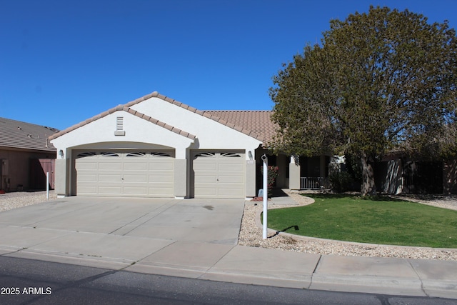 single story home featuring a garage, concrete driveway, a tiled roof, a front yard, and stucco siding