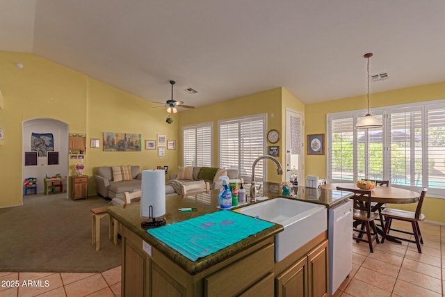 kitchen with a kitchen island with sink, a sink, visible vents, hanging light fixtures, and dishwasher