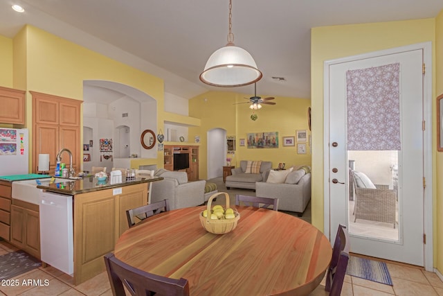 dining room with vaulted ceiling, ceiling fan, light tile patterned flooring, and arched walkways