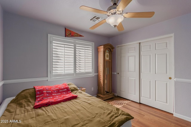 bedroom with a ceiling fan, light wood-style flooring, visible vents, and a closet