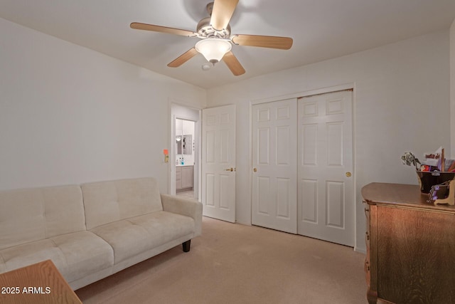 living room featuring a ceiling fan and light colored carpet