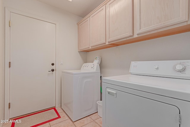 laundry area featuring light tile patterned flooring, cabinet space, and separate washer and dryer