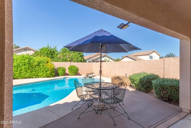 view of swimming pool featuring a patio area, a fenced backyard, a fenced in pool, and outdoor dining space