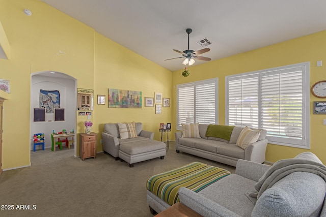 living area featuring lofted ceiling, a wealth of natural light, visible vents, and a ceiling fan