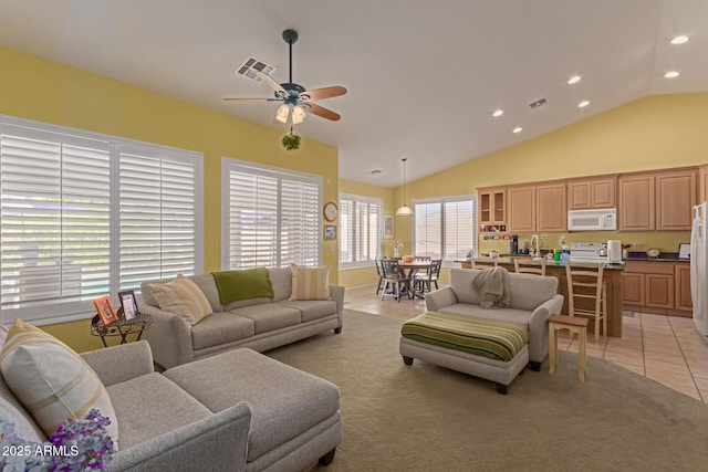 living room featuring light tile patterned floors, ceiling fan, lofted ceiling, and visible vents