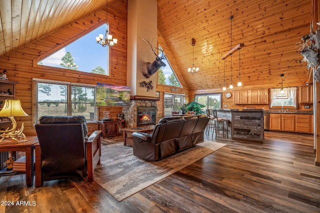 living room featuring sink, wooden walls, high vaulted ceiling, dark hardwood / wood-style floors, and a fireplace