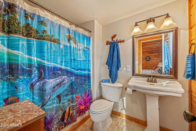 bathroom featuring a textured ceiling, tile patterned flooring, toilet, and a shower with shower curtain