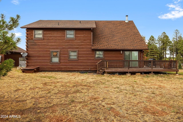 rear view of property featuring a yard and a deck