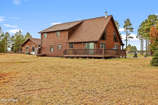 rear view of property with a wooden deck and a yard