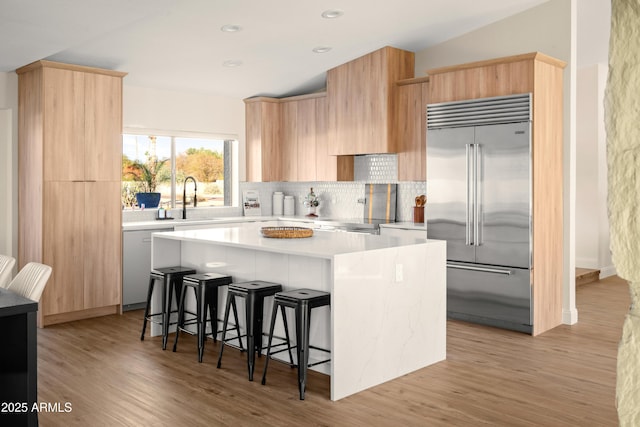 8001 E Voltaire Ave, Scottsdale, AZ 85260 - kitchen with stainless steel built in refrigerator, a kitchen island, light countertops, modern cabinets, and backsplash