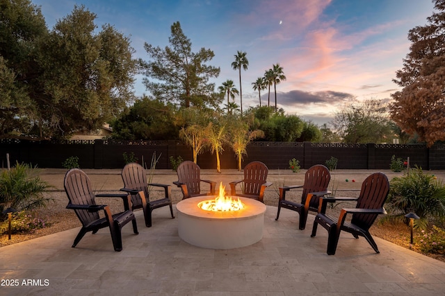 8001 E Voltaire Ave, Scottsdale, AZ 85260 - patio terrace at dusk featuring an outdoor fire pit, a patio, and a fenced backyard
