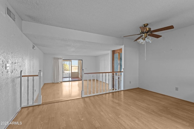 unfurnished room featuring light hardwood / wood-style floors and a textured ceiling