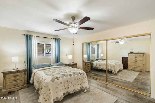 bedroom with ceiling fan, light hardwood / wood-style flooring, and a closet