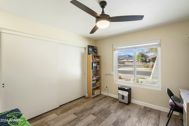 misc room featuring heating unit, ceiling fan, and light hardwood / wood-style flooring