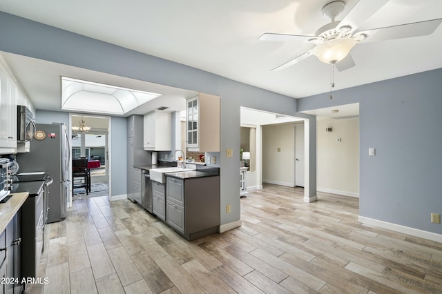 kitchen featuring appliances with stainless steel finishes, gray cabinets, white cabinetry, and light hardwood / wood-style flooring