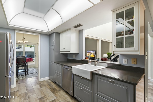 kitchen with a chandelier, appliances with stainless steel finishes, white cabinets, and gray cabinetry