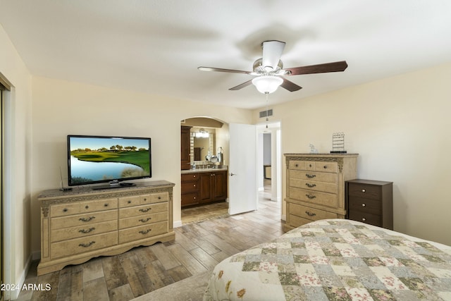 bedroom with connected bathroom, light hardwood / wood-style flooring, and ceiling fan