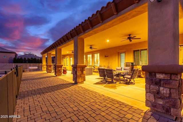 patio terrace at dusk featuring ceiling fan