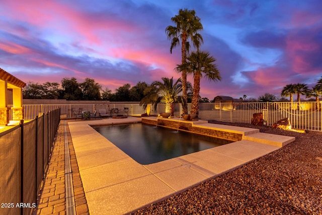 pool at dusk with a patio area