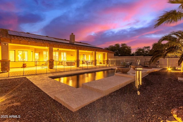 pool at dusk with a patio area