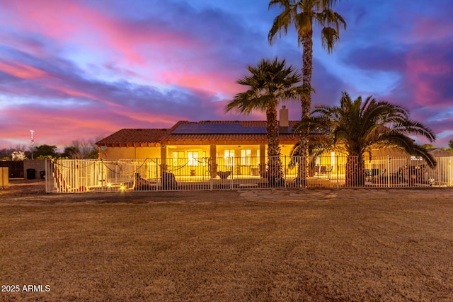 view of front of house with a yard and solar panels