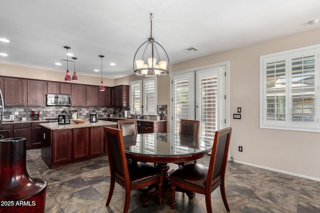 dining space featuring a notable chandelier and sink